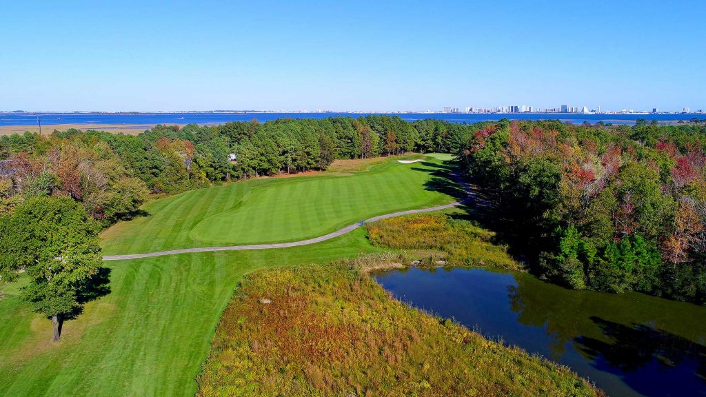 Golf course next to water and trees