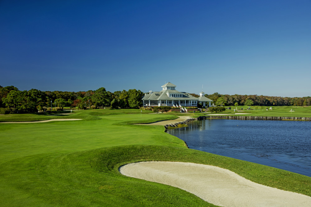 Golf course next to pond and house