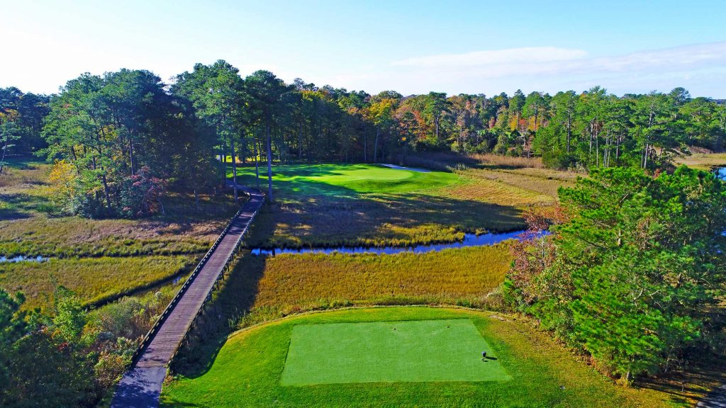 View of golf course next to bridge and creek