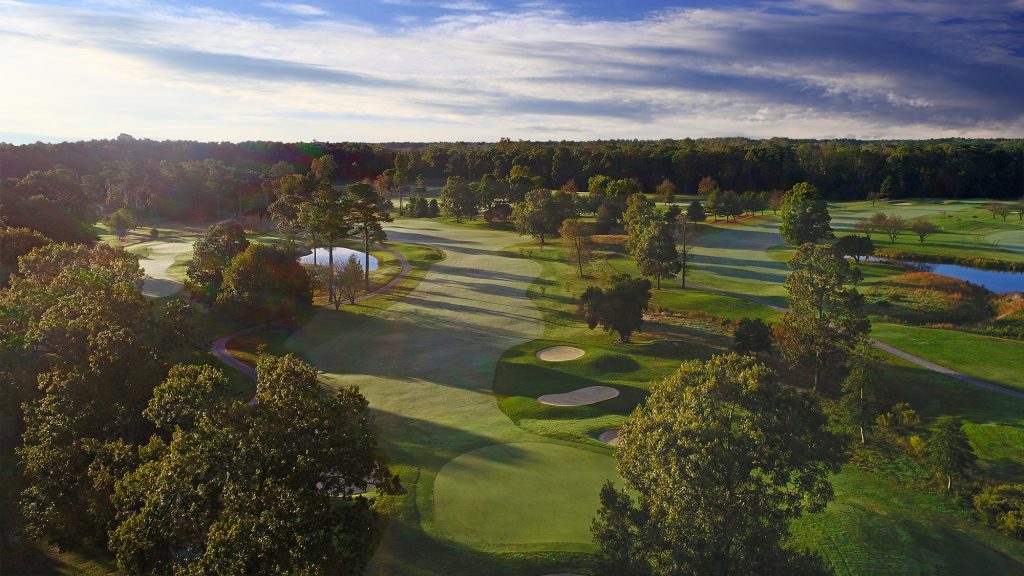 Aerial view of golf course and trees all around